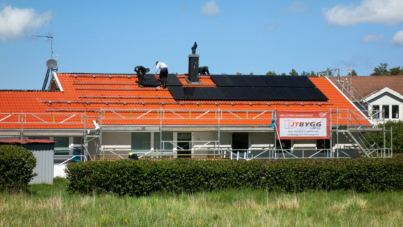 Installateurs posant des panneaux solaires sur la toiture d'une maison